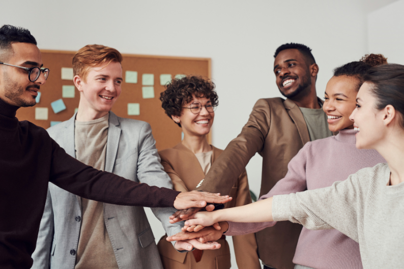 Personnes diverses unissant leurs mains, symbole d’équité et d’inclusion.